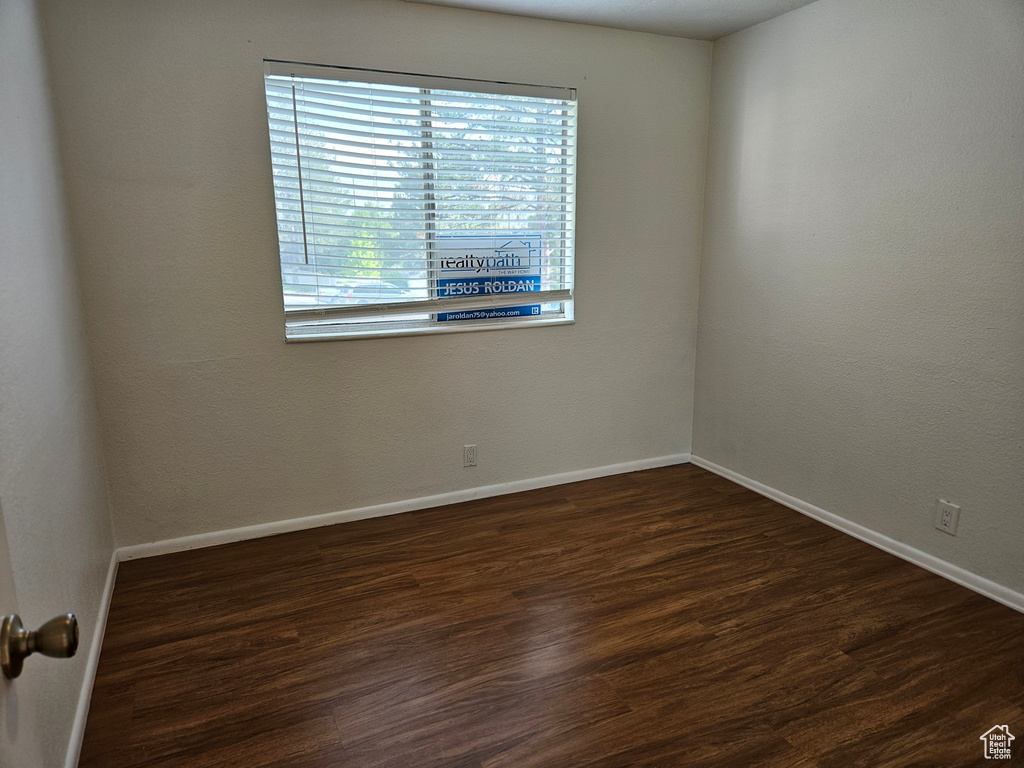 Spare room with baseboards and wood finished floors