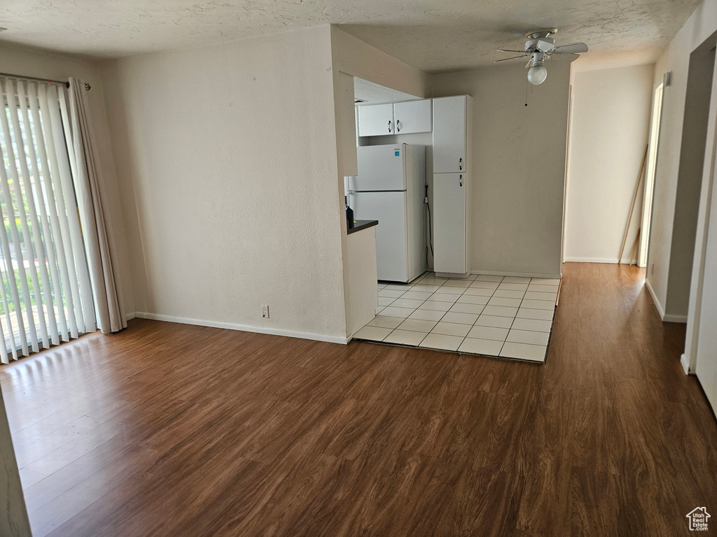 Spare room featuring ceiling fan, light wood-type flooring, and a textured ceiling