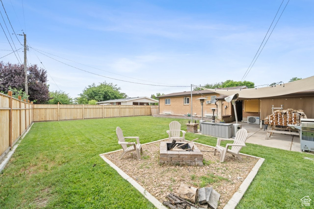Fenced backyard featuring an outdoor fire pit and a patio