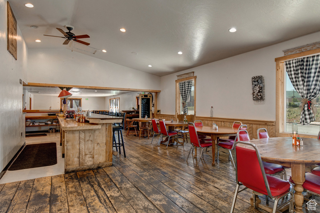 Dining area with wainscoting, hardwood / wood-style flooring, vaulted ceiling, a ceiling fan, and recessed lighting