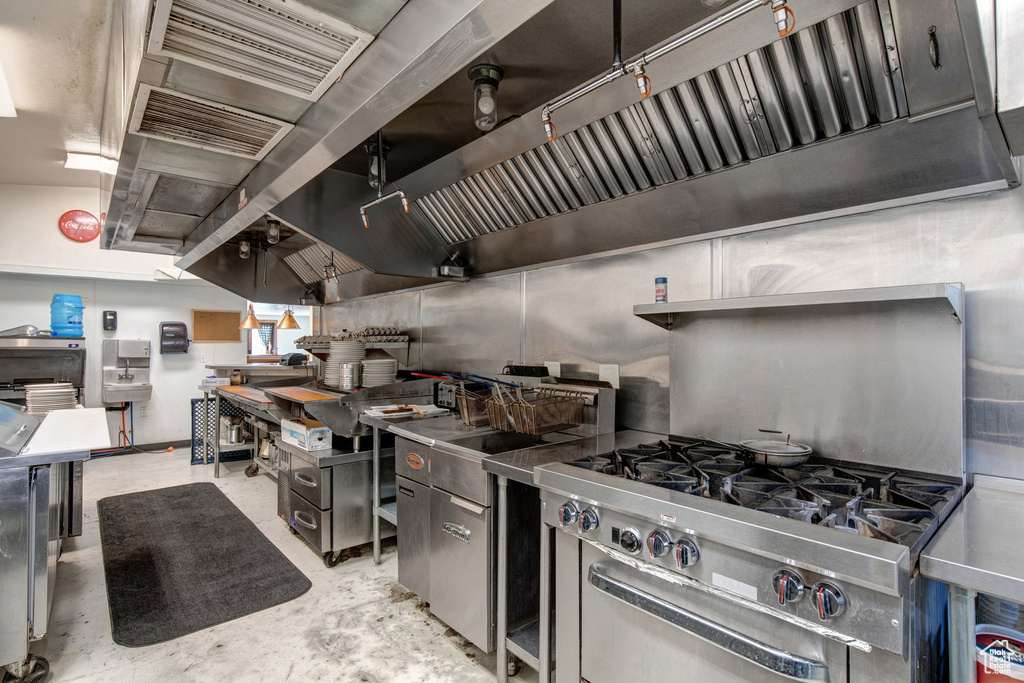 Kitchen featuring unfinished concrete floors and stainless steel range with gas cooktop