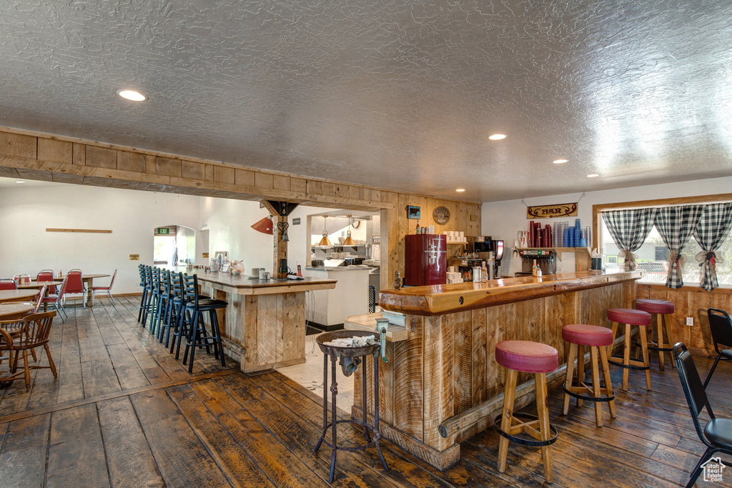 Community bar area featuring hardwood / wood-style flooring and recessed lighting