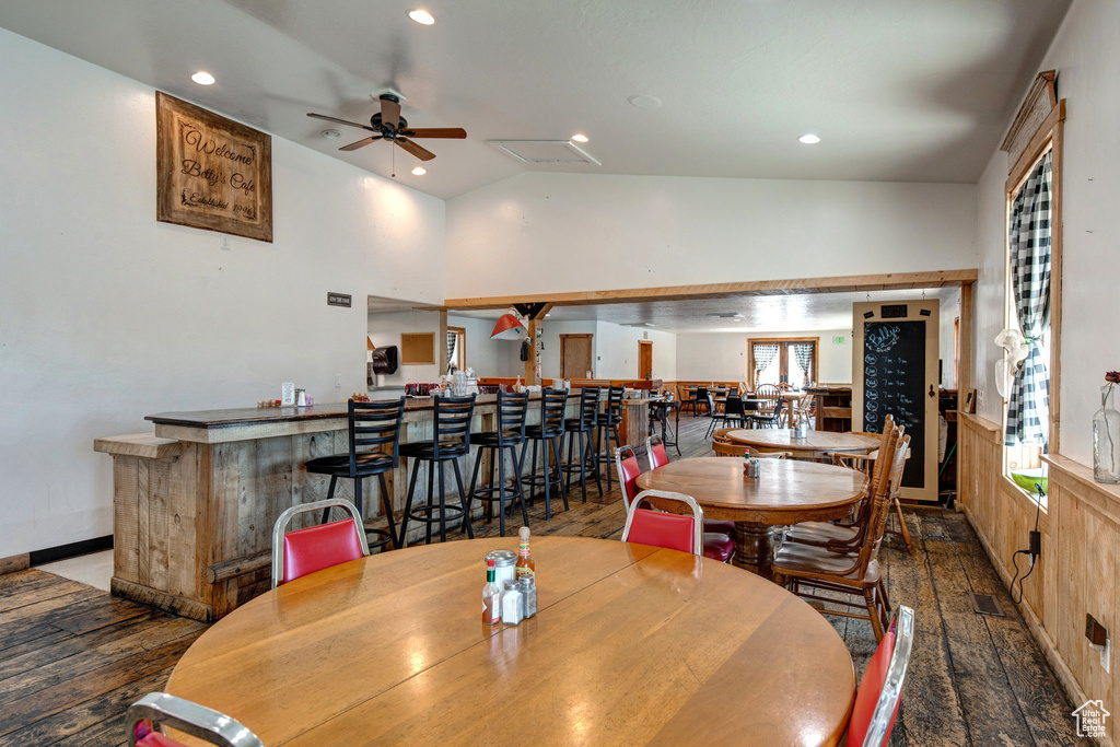 Dining space featuring a bar, a ceiling fan, recessed lighting, vaulted ceiling, and wood finished floors