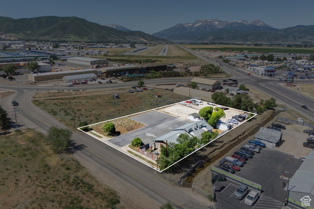 Aerial view of property and surrounding area featuring property boundaries highlighted and a mountain backdrop