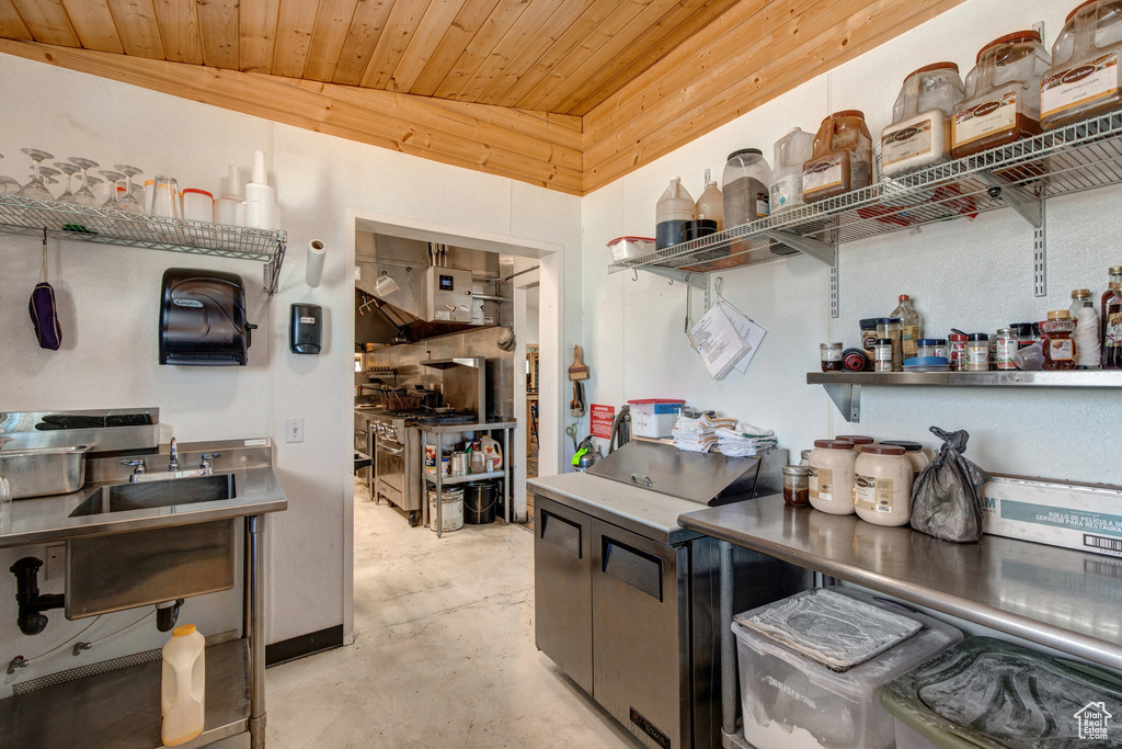 Kitchen with open shelves, concrete floors, and wood ceiling