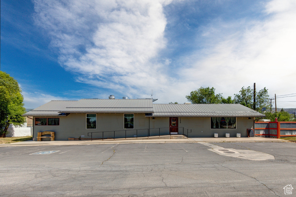 Ranch-style house featuring a metal roof and uncovered parking