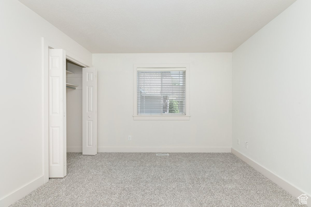Unfurnished bedroom featuring light colored carpet