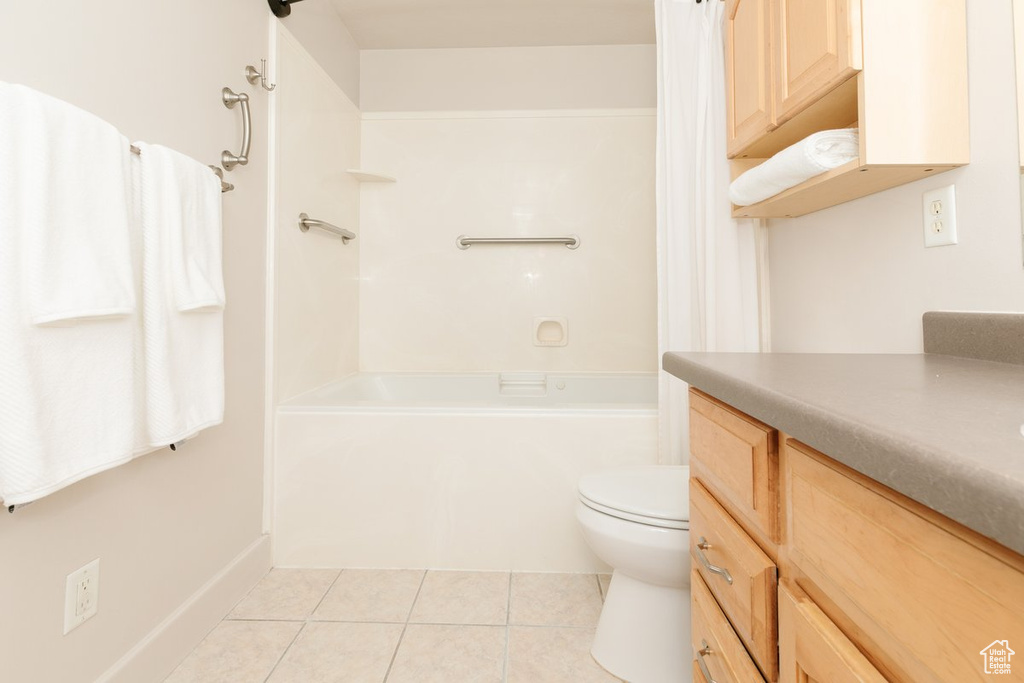 Full bath with tile patterned floors, vanity, and shower / bath combo