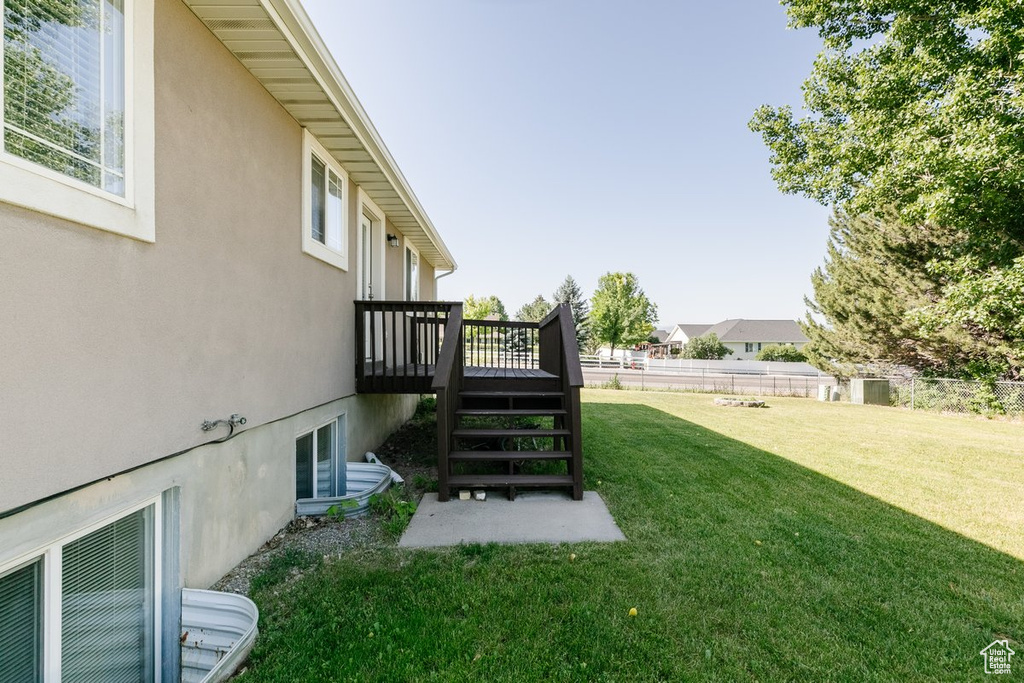 View of yard with a wooden deck and stairs