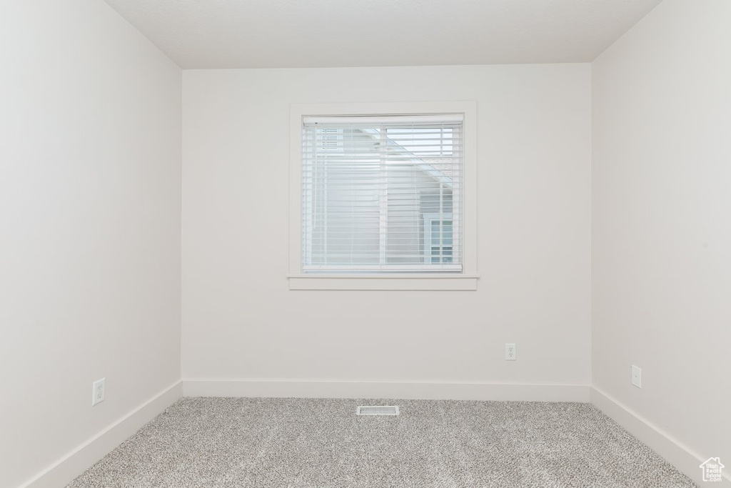 Carpeted empty room with baseboards