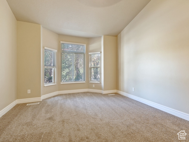 Carpeted empty room featuring baseboards