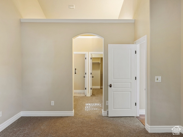 Spare room featuring carpet floors and arched walkways