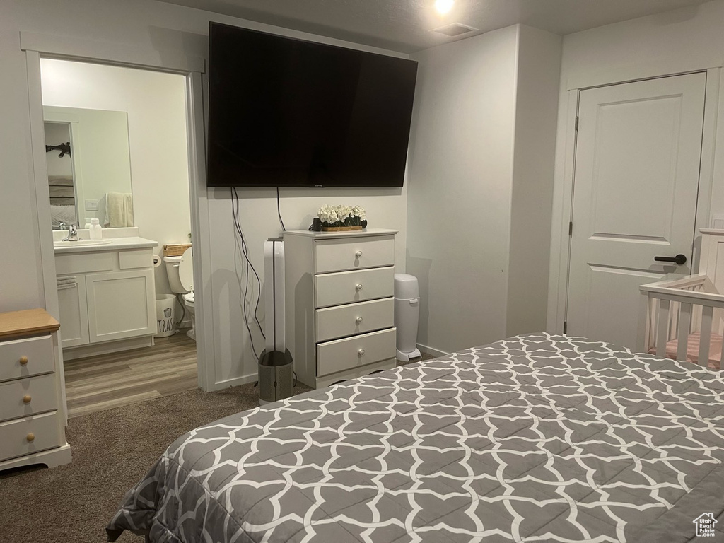 Carpeted bedroom featuring a sink and ensuite bathroom