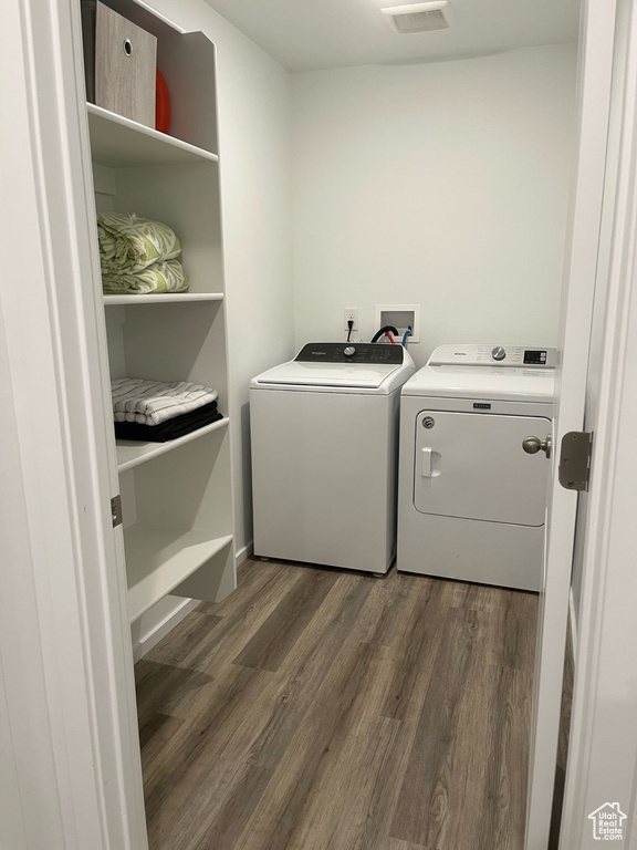 Laundry room featuring washer and clothes dryer and dark wood finished floors