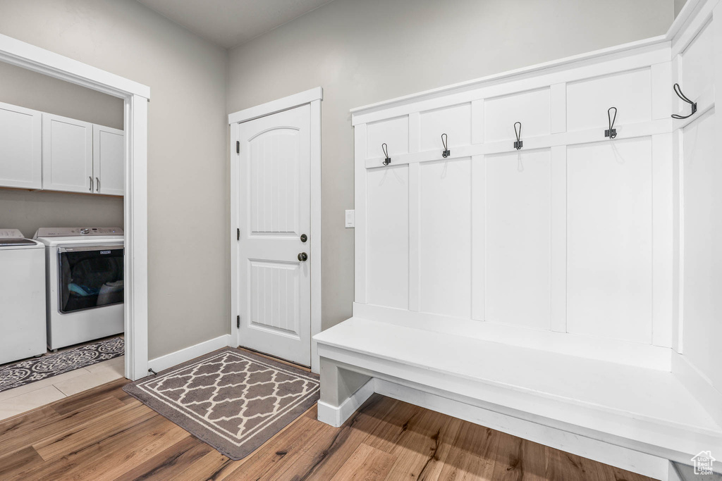 Mudroom with separate washer and dryer and wood finished floors