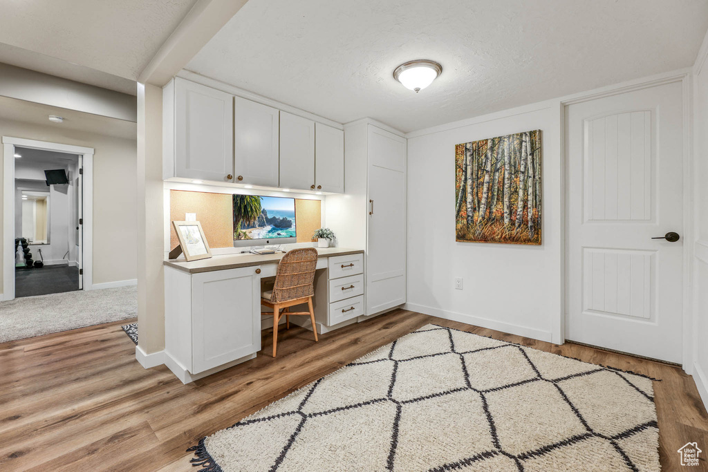 Office area with built in desk and light wood finished floors
