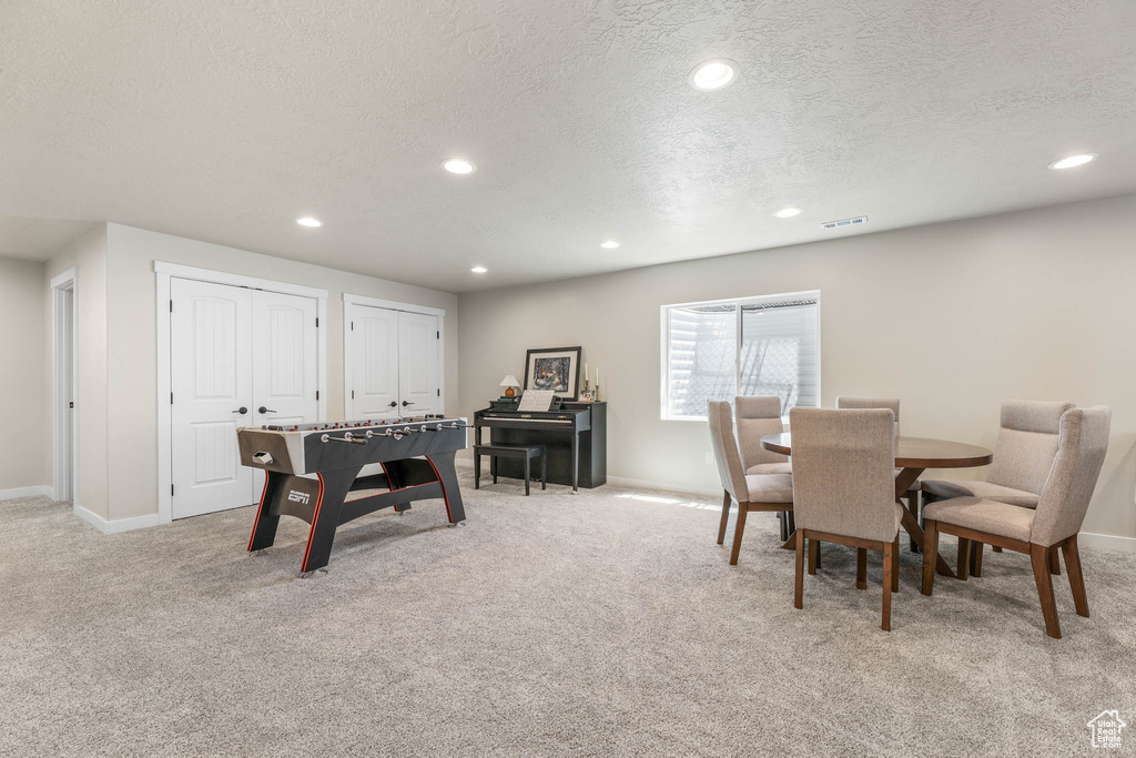 Rec room featuring light colored carpet, a textured ceiling, and recessed lighting