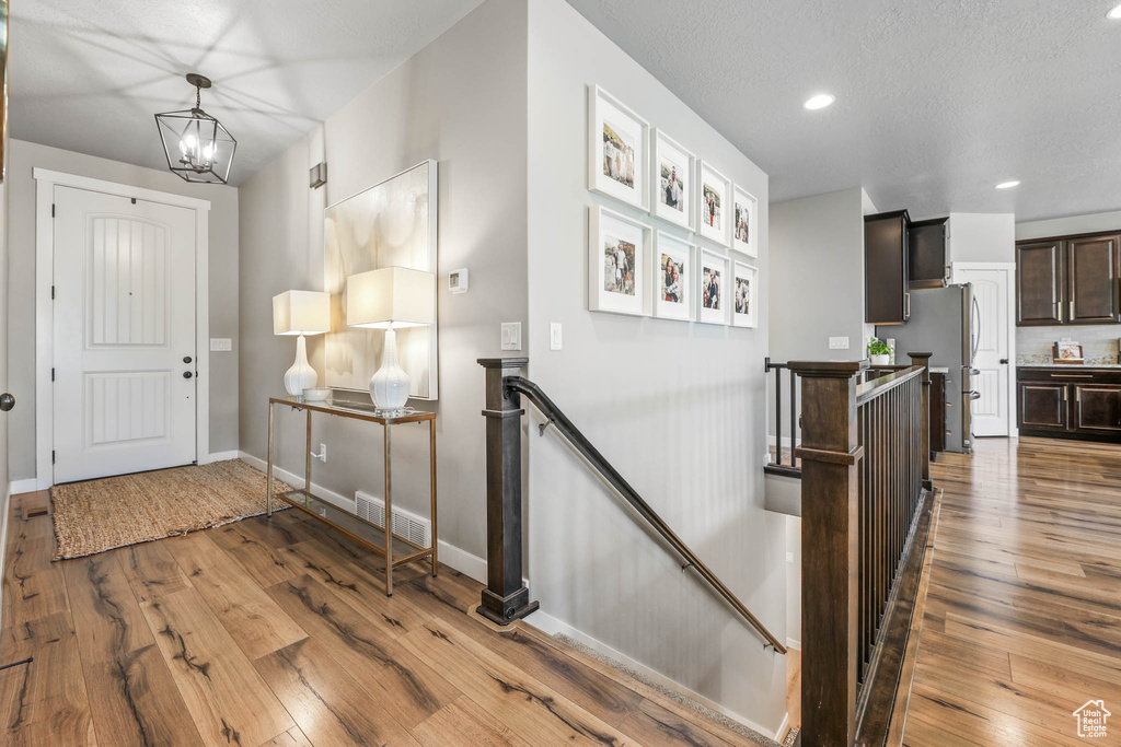 Entryway with hardwood / wood-style floors, recessed lighting, and a chandelier