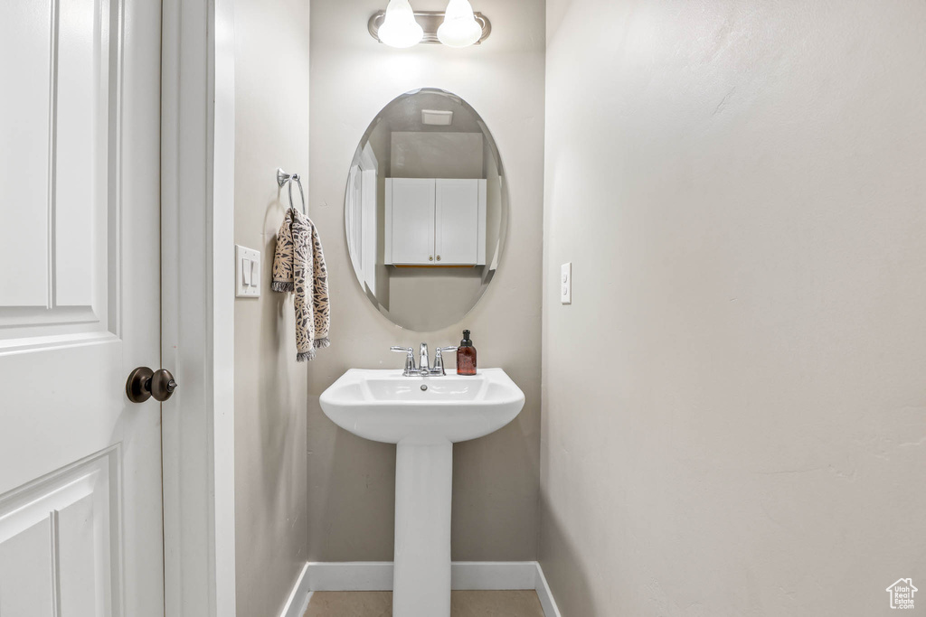 Bathroom featuring baseboards and a sink
