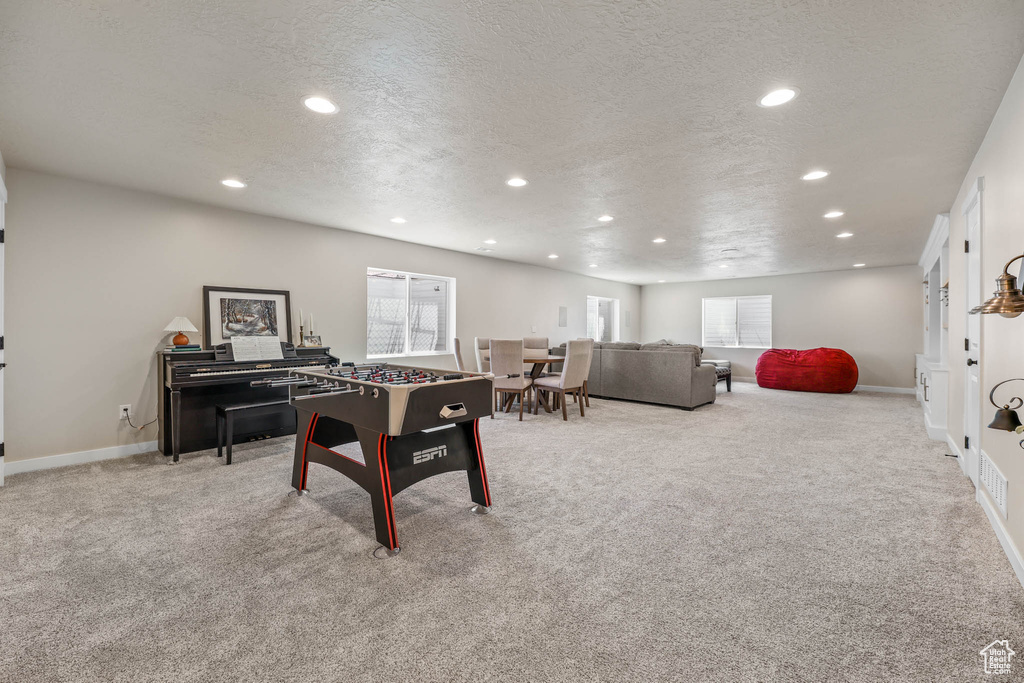 Recreation room with recessed lighting, a textured ceiling, and carpet