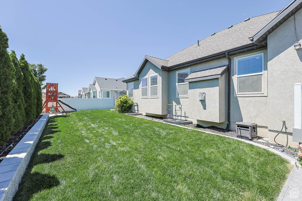 Fenced backyard featuring a playground