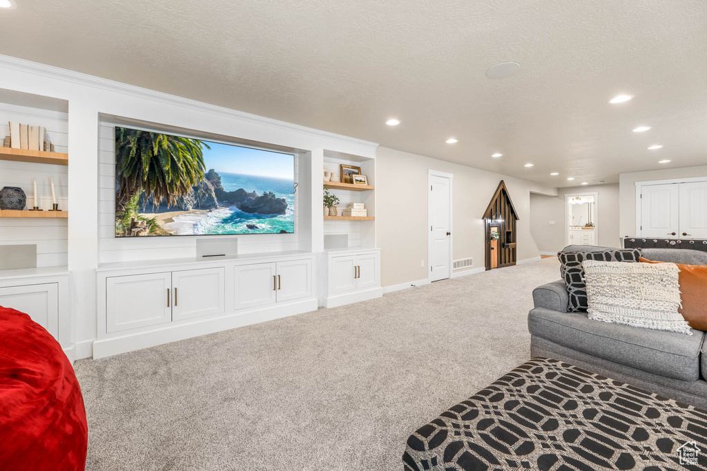 Carpeted living room with recessed lighting and built in features