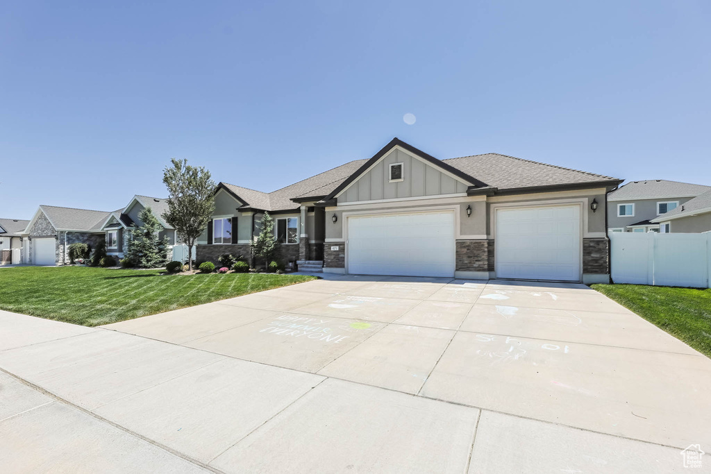 View of front of property featuring concrete driveway, board and batten siding, an attached garage, and stone siding