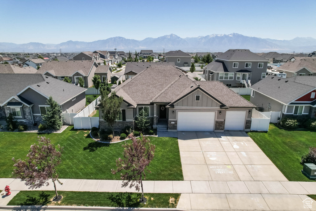 Craftsman house featuring a residential view, an attached garage, board and batten siding, stone siding, and concrete driveway