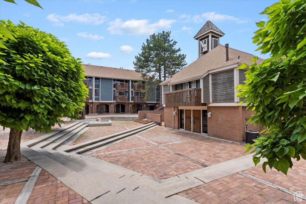 Rear view of house with brick siding and a balcony
