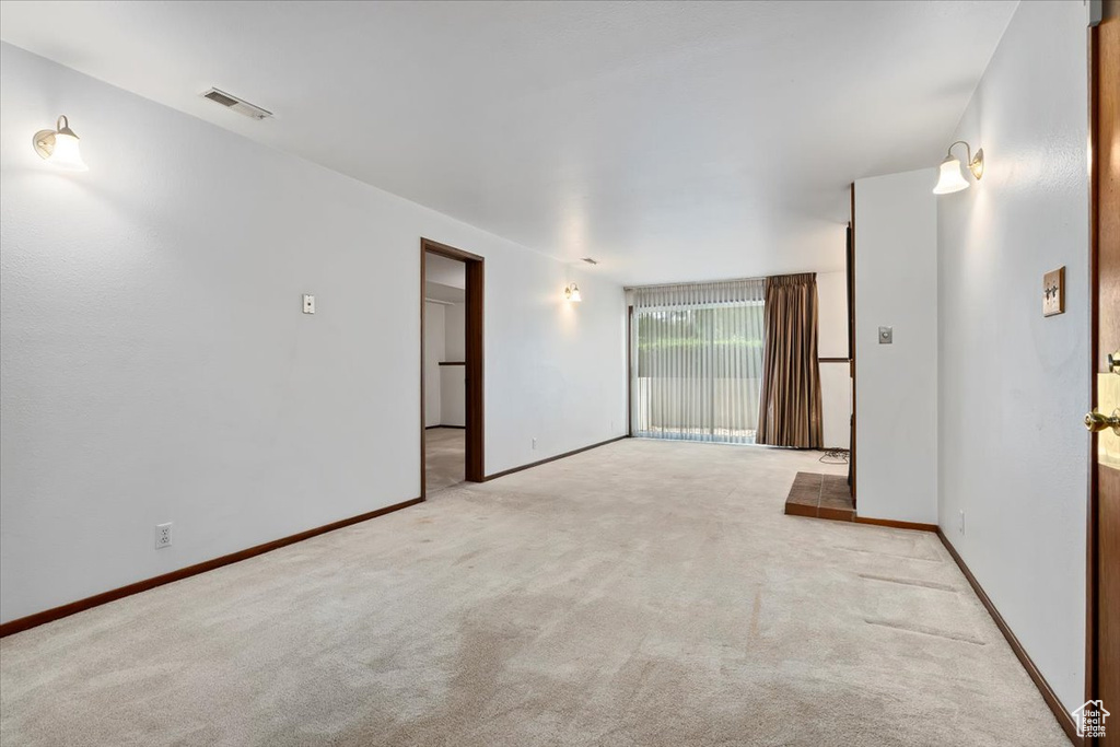 Carpeted spare room with baseboards