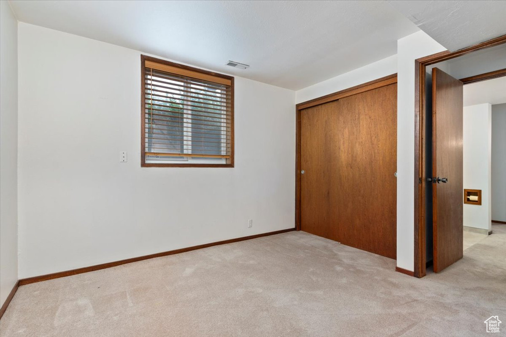 Unfurnished bedroom featuring carpet floors and a closet