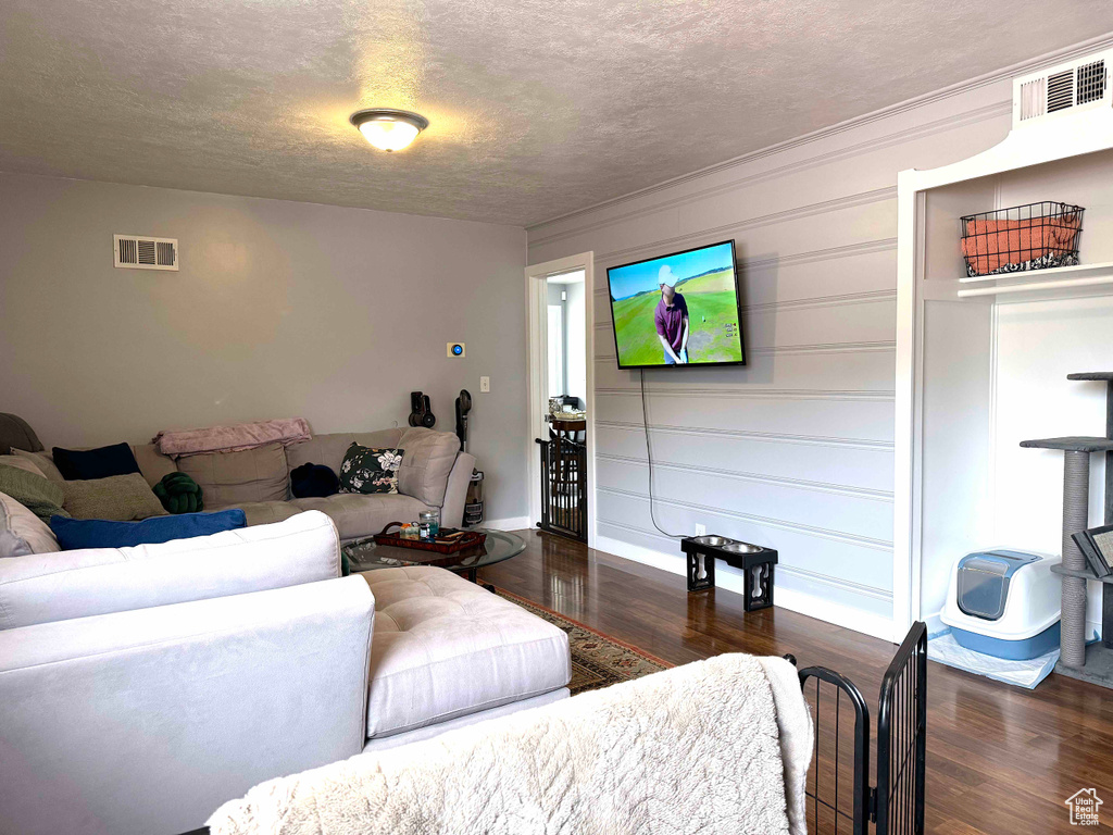 Living area featuring wood finished floors and a textured ceiling