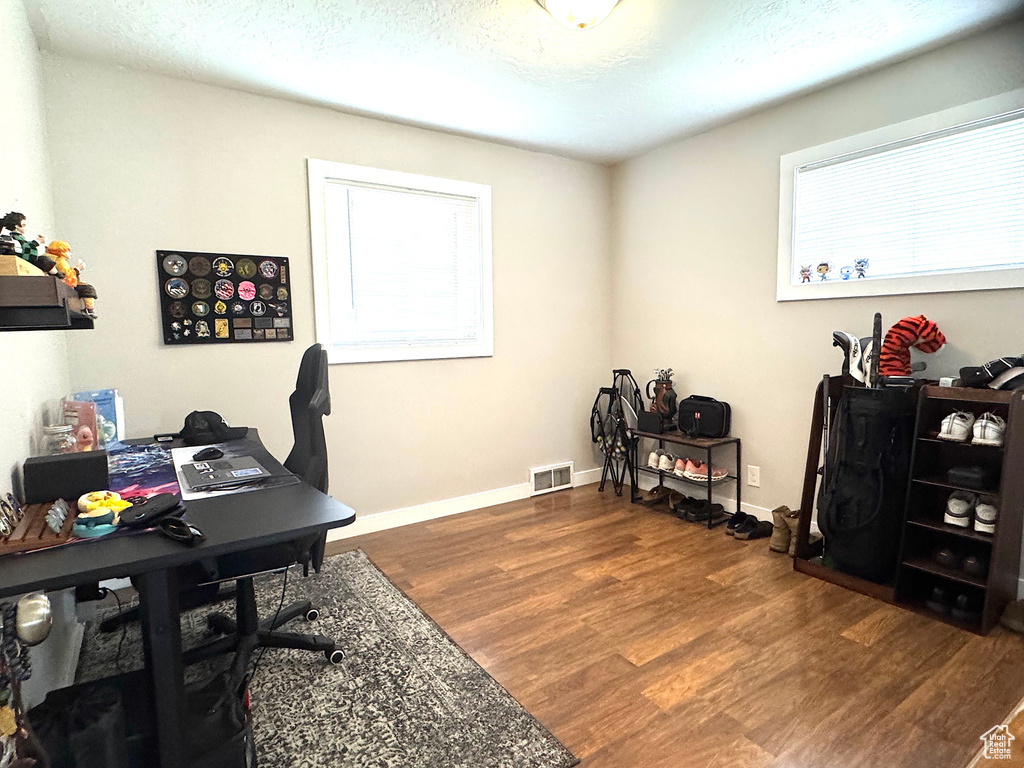 Office featuring dark wood-style flooring and a textured ceiling