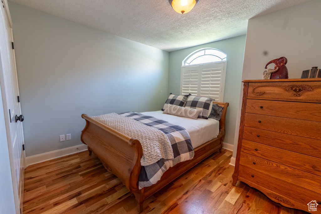 Bedroom featuring light wood-style floors and a textured ceiling