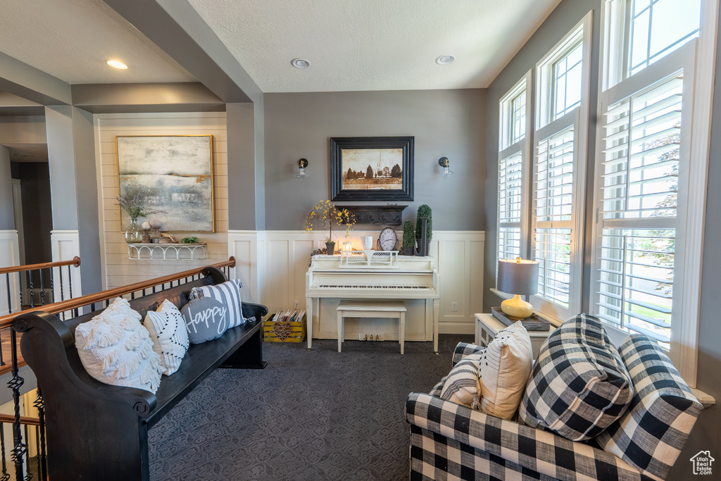 Living room with a decorative wall, a wainscoted wall, carpet, and recessed lighting