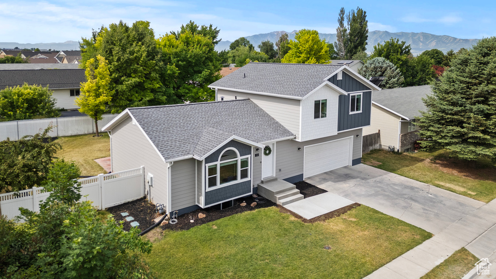 Traditional-style house featuring roof with shingles, an attached garage, driveway, and a mountain view