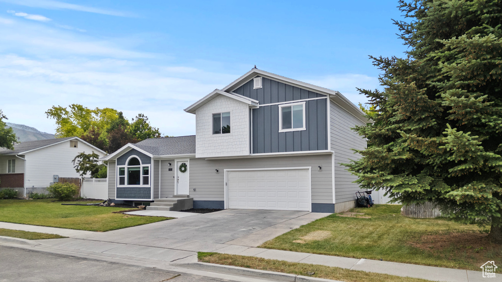 View of front of home with board and batten siding, concrete driveway, and an attached garage