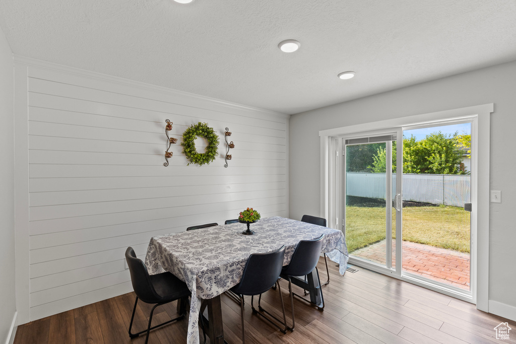 Dining area featuring wood finished floors, wooden walls, and recessed lighting