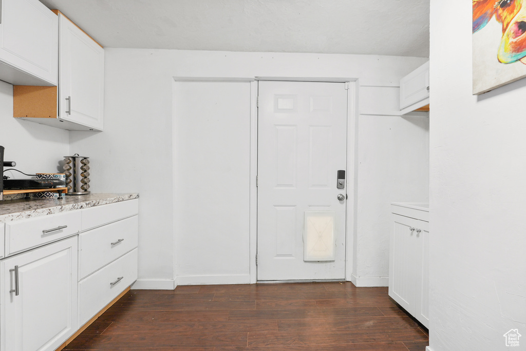 Kitchen with dark wood-style floors and white cabinetry