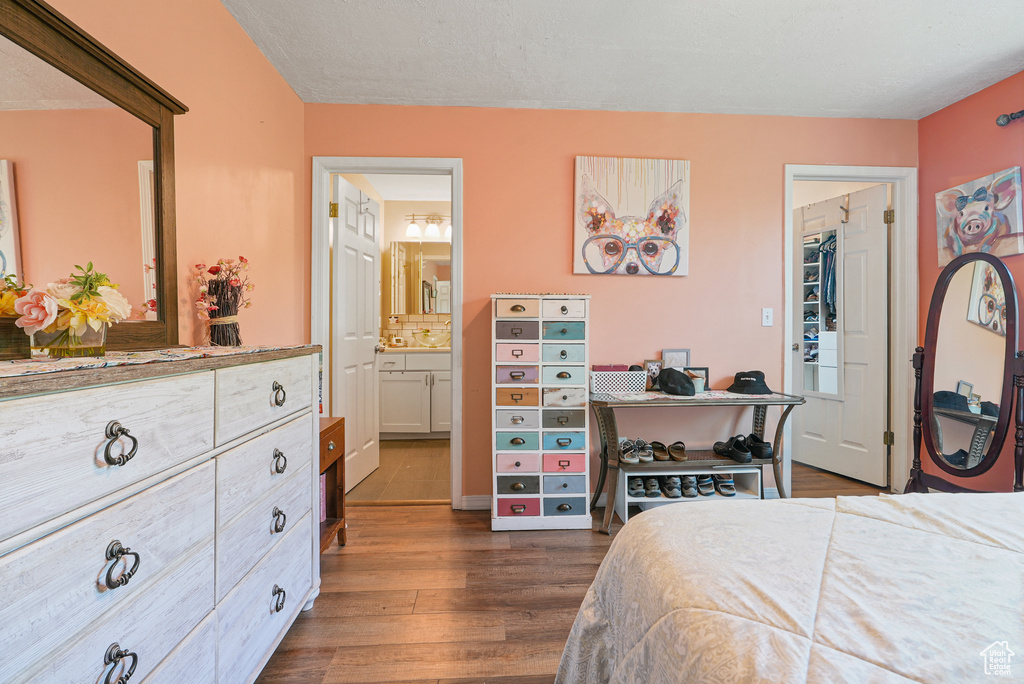 Bedroom with dark wood finished floors and connected bathroom
