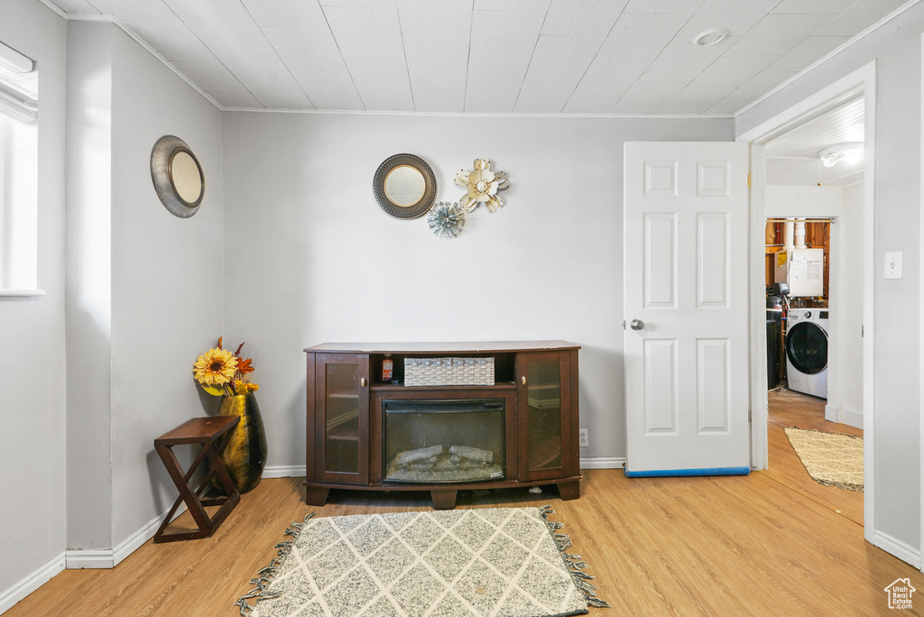 Detailed view of wood finished floors, independent washer and dryer, and ornamental molding