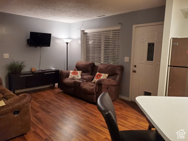 Living area with wood finished floors and a textured ceiling