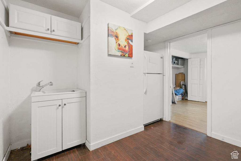 Hallway with a sink and dark wood-type flooring