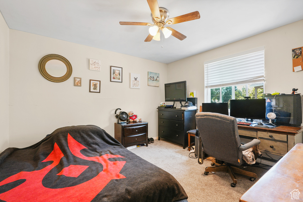 Bedroom with carpet flooring, an office area, and a ceiling fan