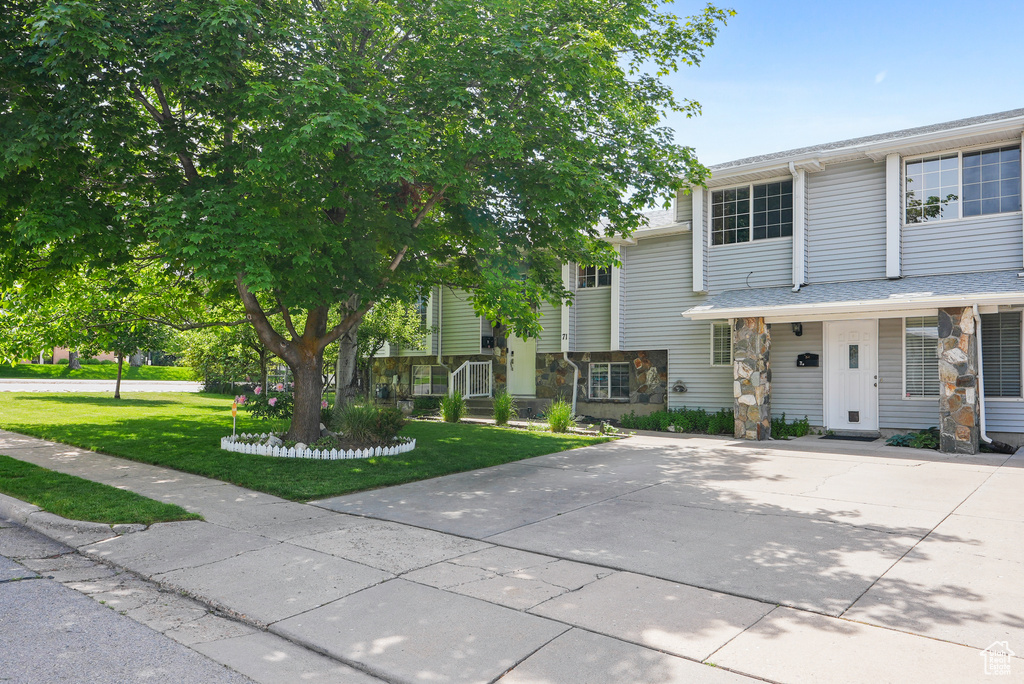 View of front facade featuring stone siding and a front lawn
