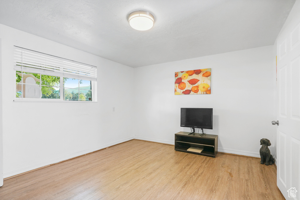 Unfurnished room with wood finished floors and baseboards