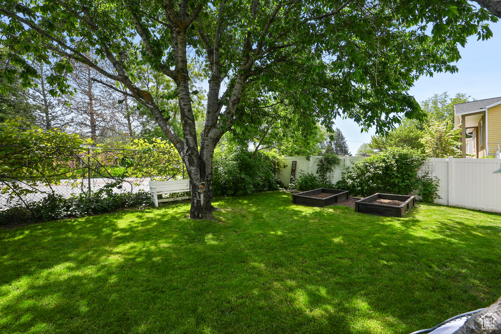Fenced yard featuring a vegetable garden