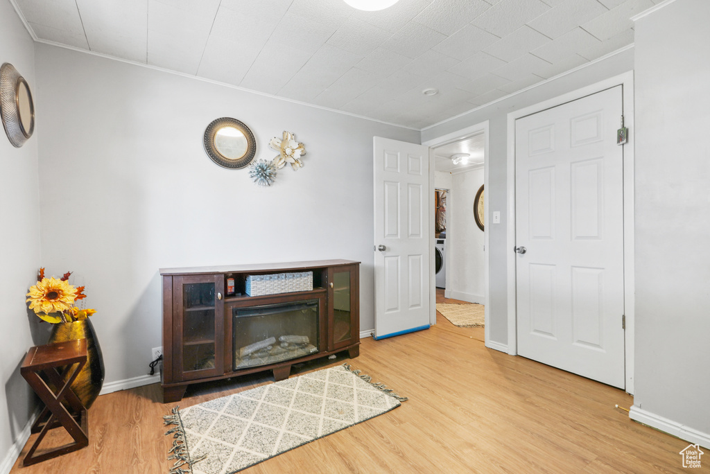 Entrance foyer featuring wood finished floors, crown molding, and washer / dryer