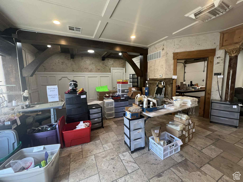 Misc room with stone tile floors, recessed lighting, a decorative wall, and wainscoting