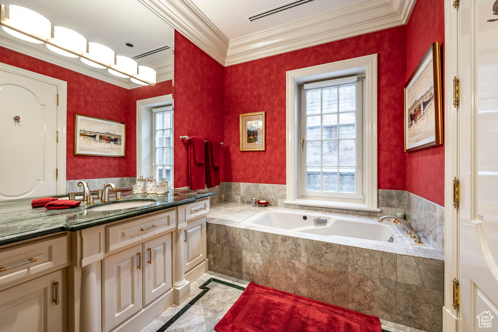 Bathroom with vanity, crown molding, and a bath